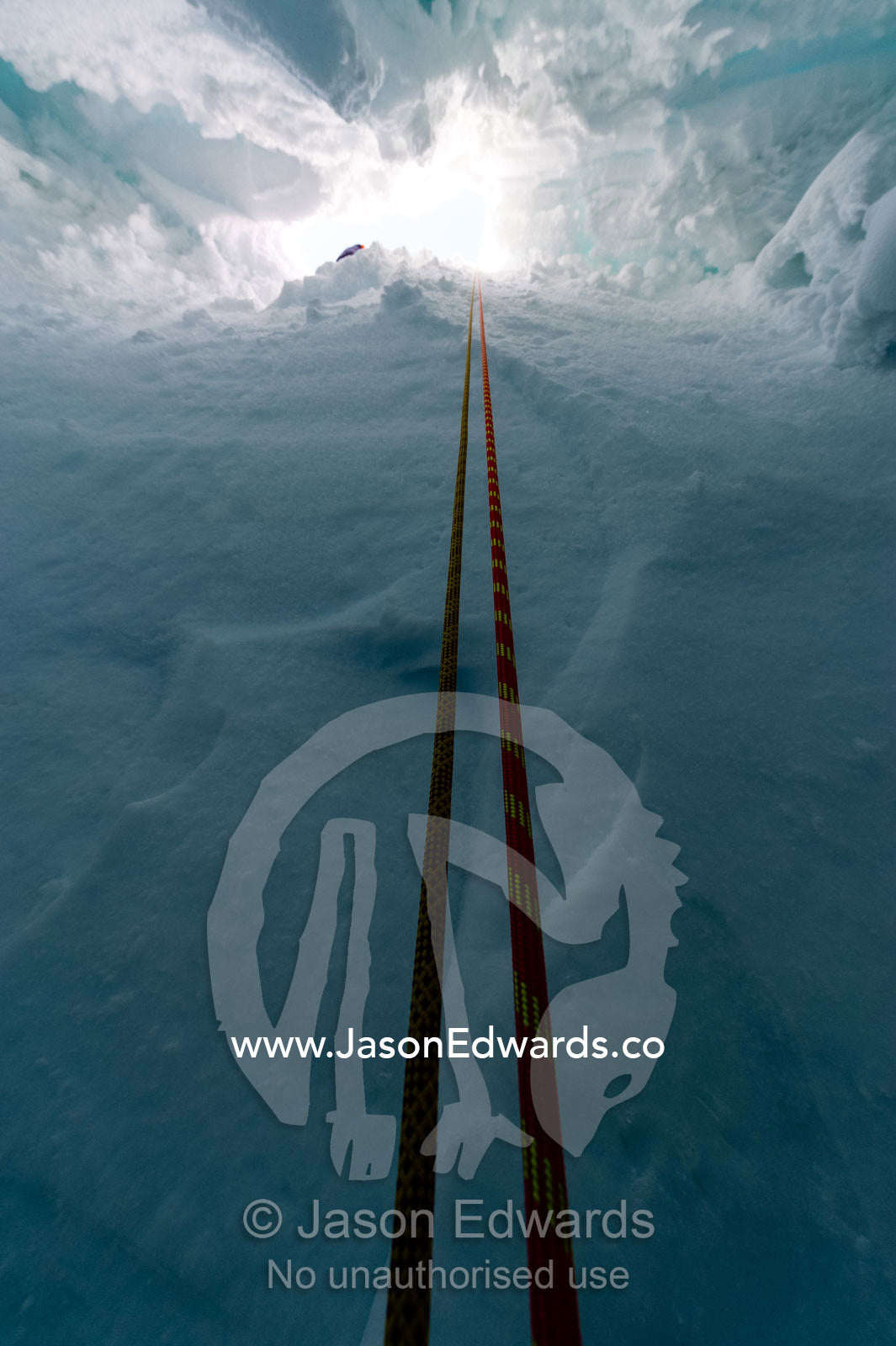 Ropes descending into the entrance of a crevasse on the slopes of Mount Erebus in Antarctica. Silver City Ice Fall, Hut Point Peninsula, Ross Island Antarctica.