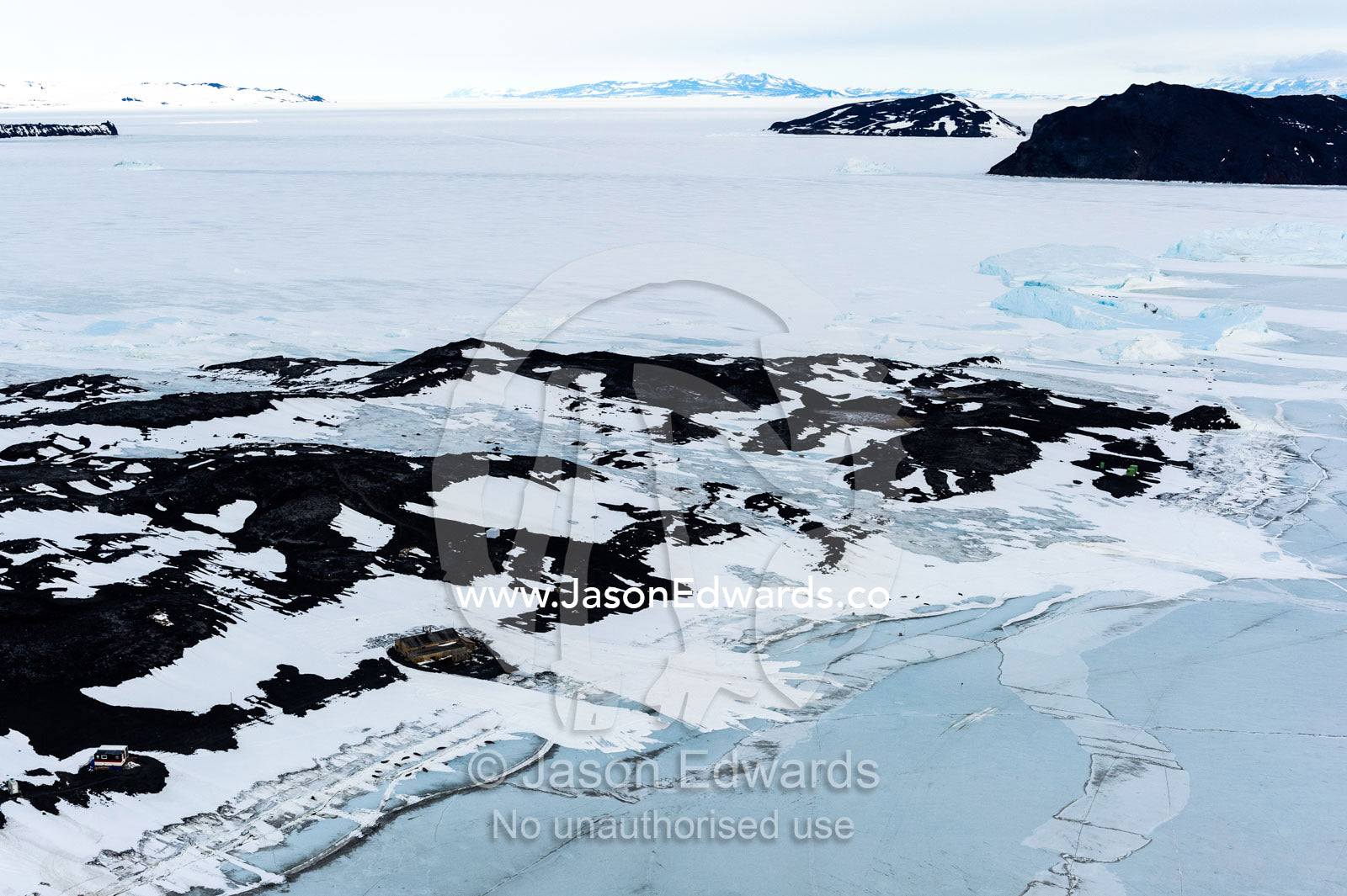 An aerial view of Antarctic explorer Robert Falcon Scott's Hut on the shore of the sea ice. Scott's Hut, Cape Evans, McMurdo Sound, Ross Island, Antarctica.