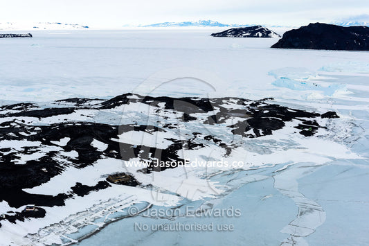 An aerial view of Antarctic explorer Robert Falcon Scott's Hut on the shore of the sea ice. Scott's Hut, Cape Evans, McMurdo Sound, Ross Island, Antarctica.