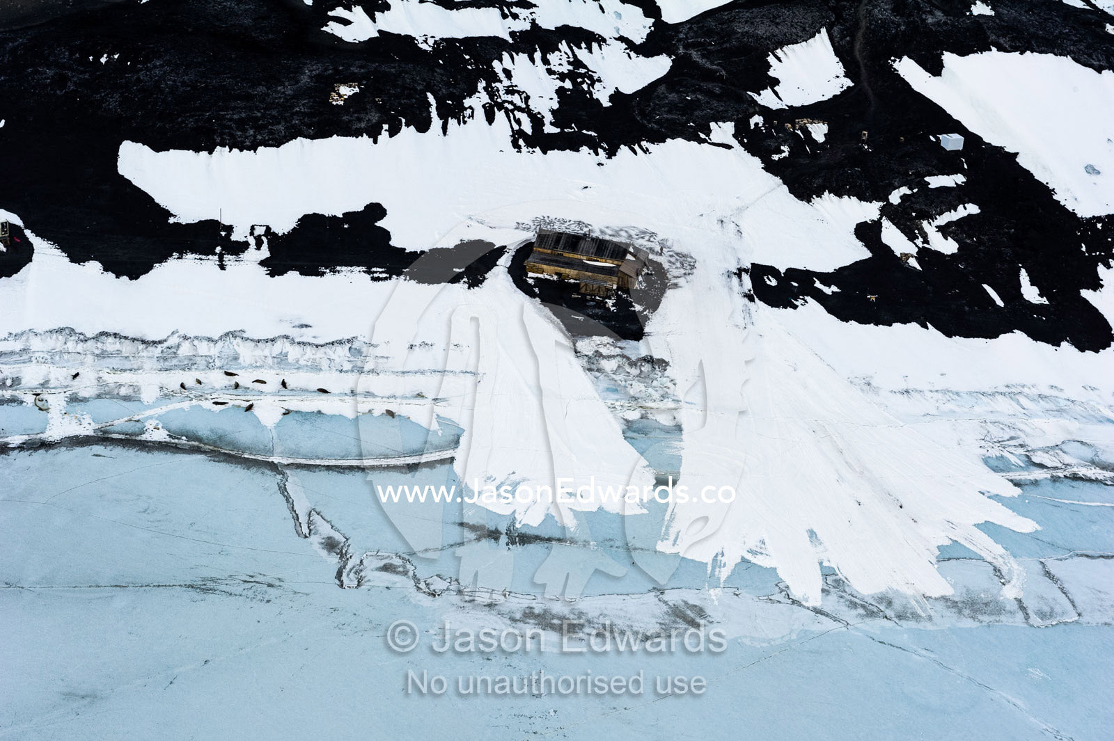 An aerial view of Antarctic explorer Robert Falcon Scott's Hut on the shore of the sea ice. Scott's Hut, Cape Evans, McMurdo Sound, Ross Island, Antarctica.