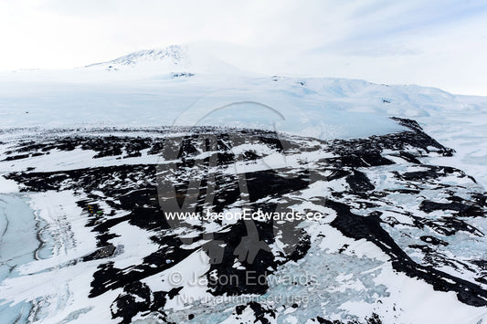 An aerial view of Antarctic explorer Robert Falcon Scott's Hut on the shore of the sea ice. Scott's Hut, Mount Erebus, Cape Evans, McMurdo Sound, Ross Island, Antarctica.