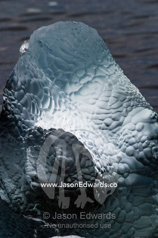 Wave motion has polished an iceberg into a sculpture of fresh water. Caughley Beach, Cape Bird, Ross Island, Antarctica.