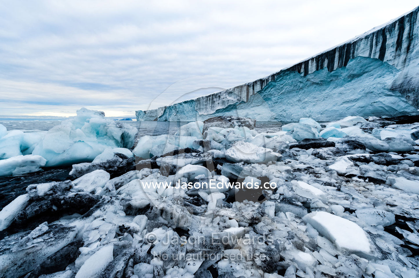 Boulders of ice gather on the beach next to a glacier fracture zone. Cape Bird Ice Cap, Adelie Glacier, Cape Bird, Ross Island, Antarctica.