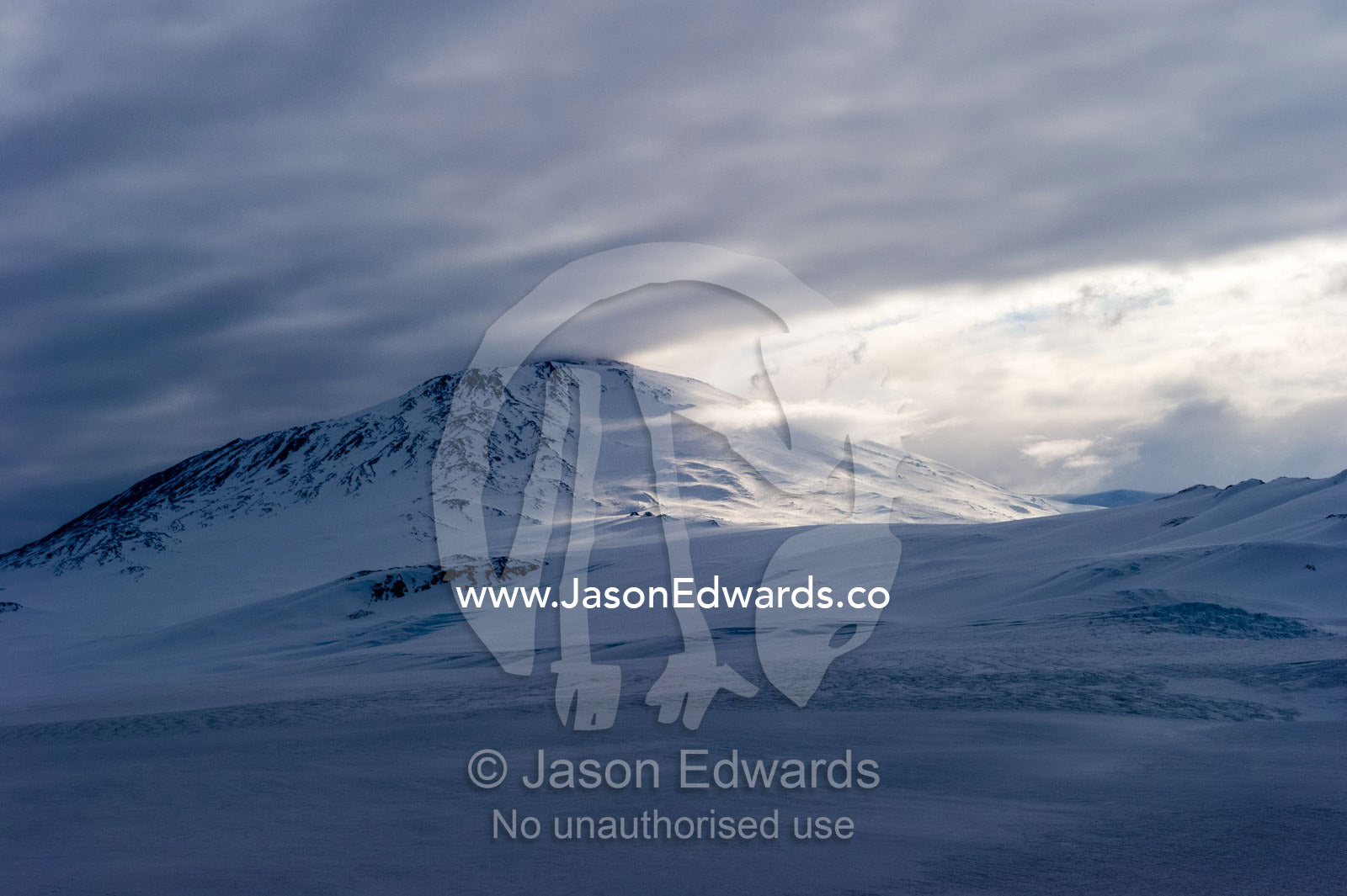 A storm descends over the summit of Mount Erebus an active volcano in Antarctica. Mount Erebus, Ross Island, Antarctica.