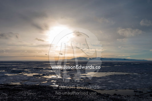 The sun reflecting off melt pools in the sea ice during an Antarctic summer. McMurdo Sound, Ross Island, Antarctica.