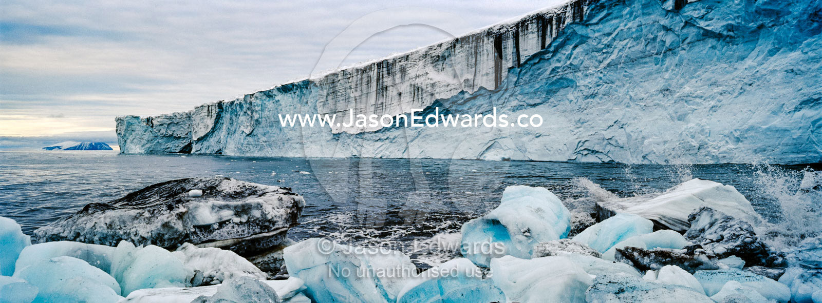 Ice boulders gather along a beach after falling from the fracture zone of a glacier. Cape Bird Ice Cap, Adelie Glacier, Cape Bird, Ross Island, Antarctica.