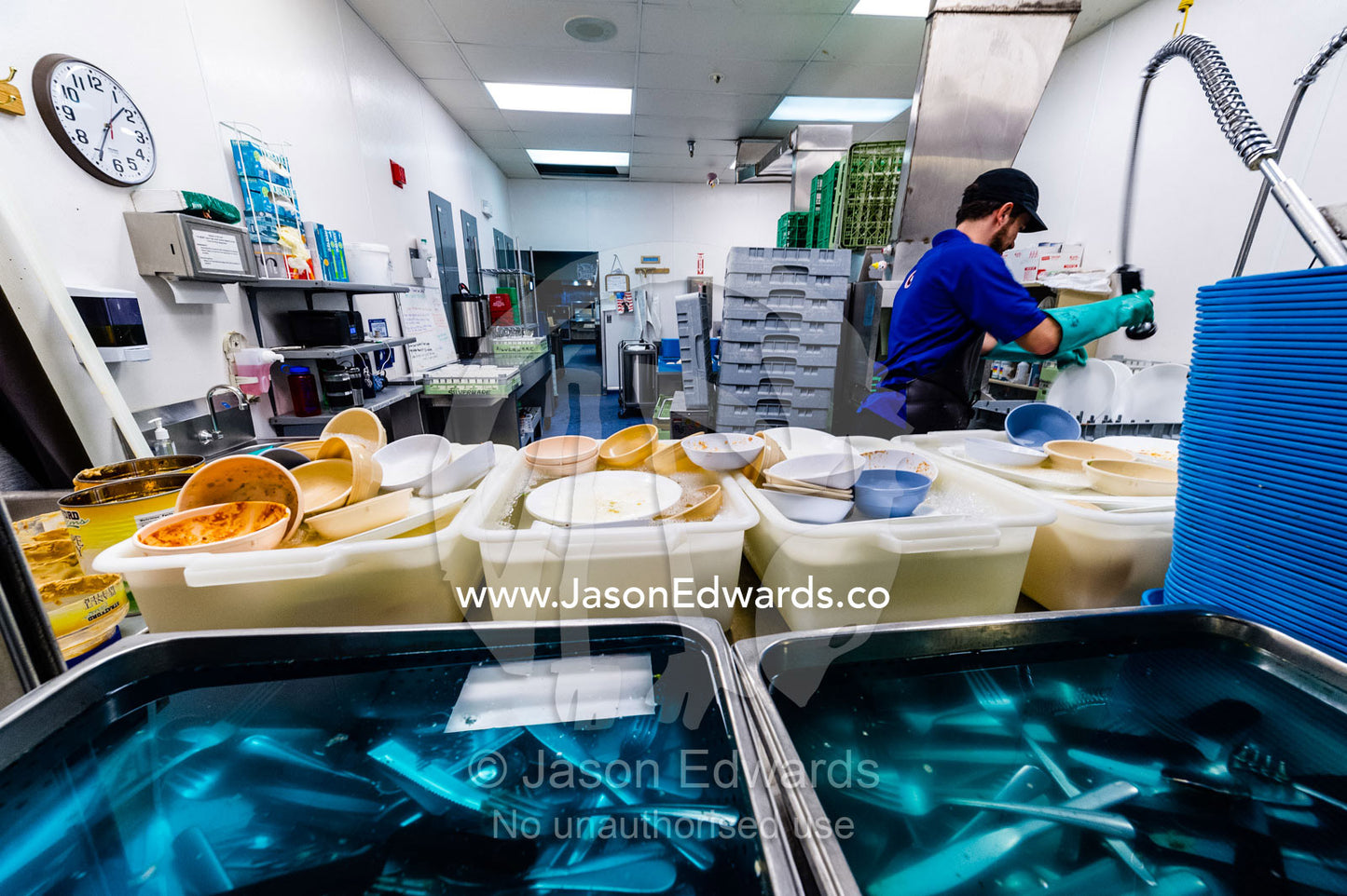 A dishwasher cleans utensils in an Antarctic base kitchen after Thanksgiving. McMurdo Station, Ross Island, Antarctica.