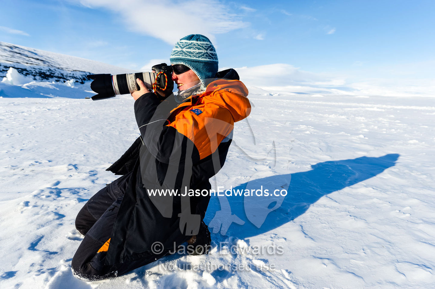 A marine mammal researcher photographing a Weddell Seal on the sea ice. Scott Base, Pram Point, Hut Point Peninsula, Ross Island, Antarctica.