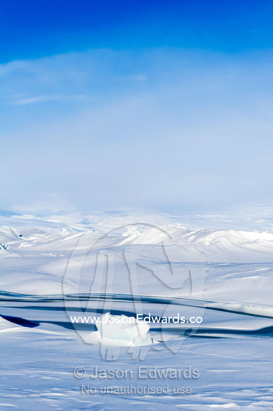 Enormous blocks of ice are pushed skyward along pressure ridges as the sea ice thins and forms melt pools. Pram Point, McMurdo Sound, Ross Island, Antarctica.