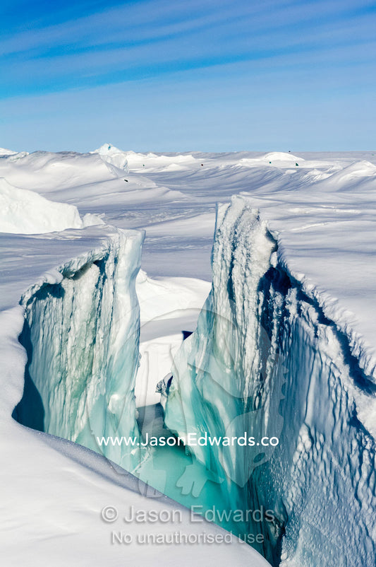 Enormous blocks of ice are pushed skyward along pressure ridges as the sea ice thins and forms melt pools. Pram Point, McMurdo Sound, Ross Island, Antarctica.
