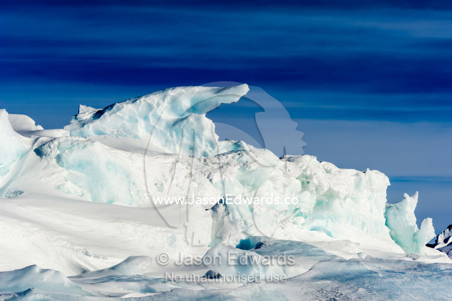 Enormous blocks of ice are pushed skyward along pressure ridges as the sea ice thins and forms melt pools. Pram Point, McMurdo Sound, Ross Island, Antarctica.