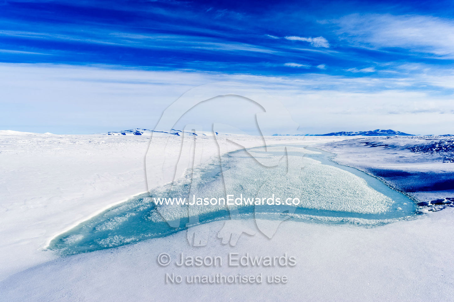 A melt pool forms on the sea ice as the Antarctic summer warms up. Pram Point, McMurdo Sound, Ross Island, Antarctica.