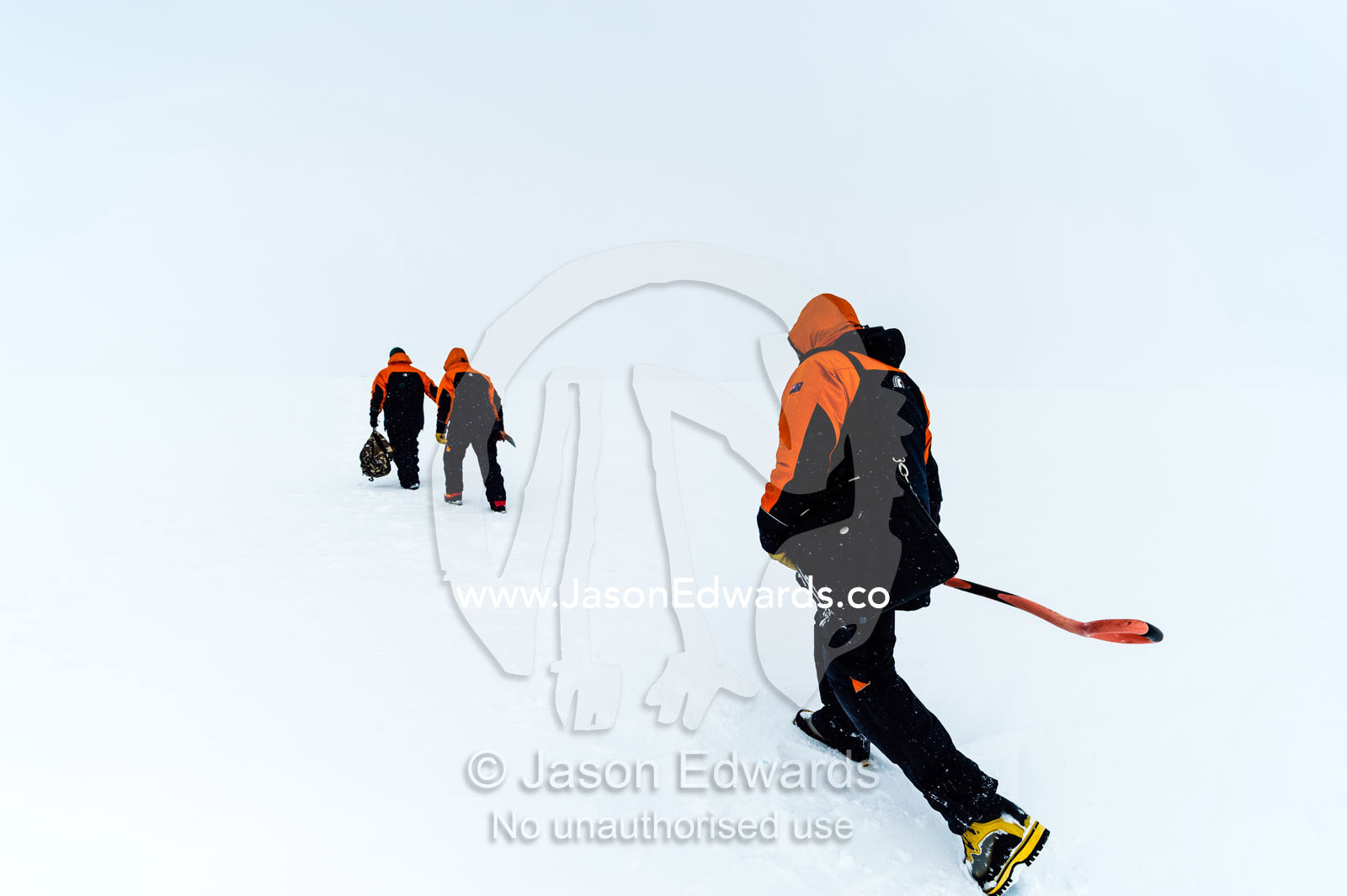 Volcanologists cross a frozen plain to change batteries in a volcano research sensor. Windless Bight, Hut Point Peninsula, Ross Island, Antarctica.