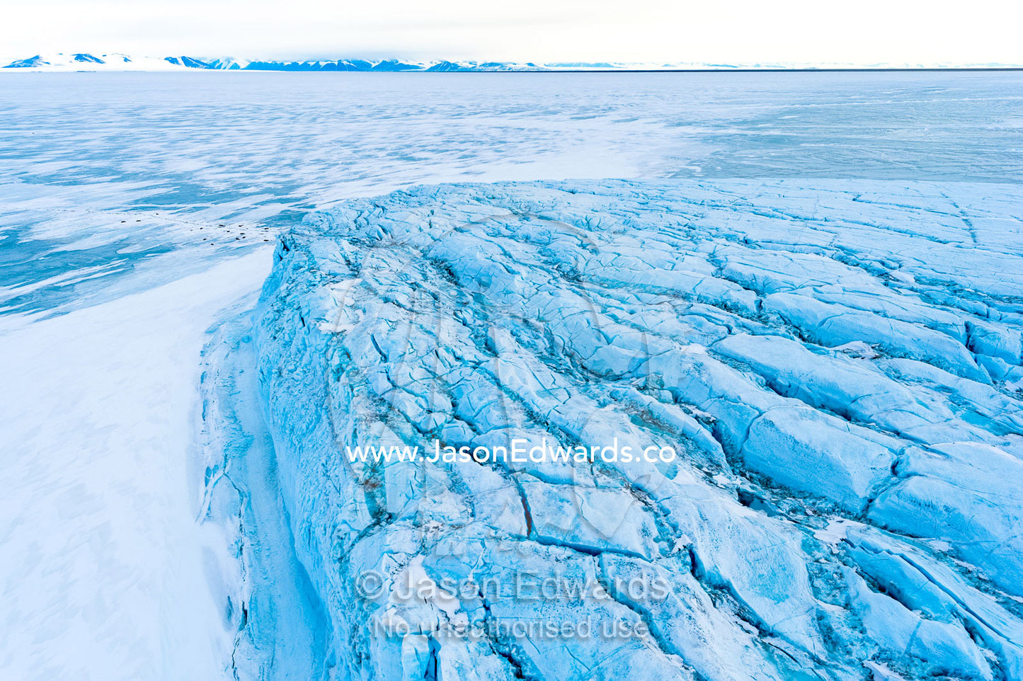 An aerial view of the tortured and fractured surface of a glacier flowing into the ocean. Barne Glacier Crack, Barne Glacier, Ross Sea, Ross Island, Antarctica.