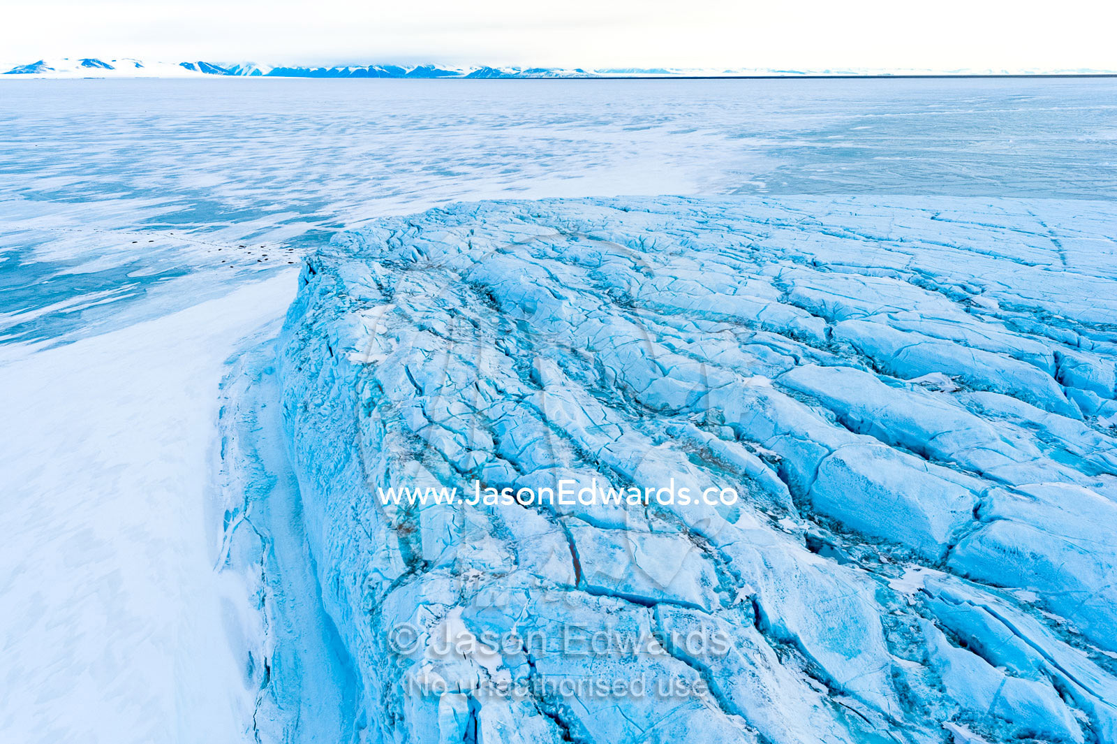 An aerial view of the tortured and fractured surface of a glacier flowing into the ocean. Barne Glacier Crack, Barne Glacier, Ross Sea, Ross Island, Antarctica.