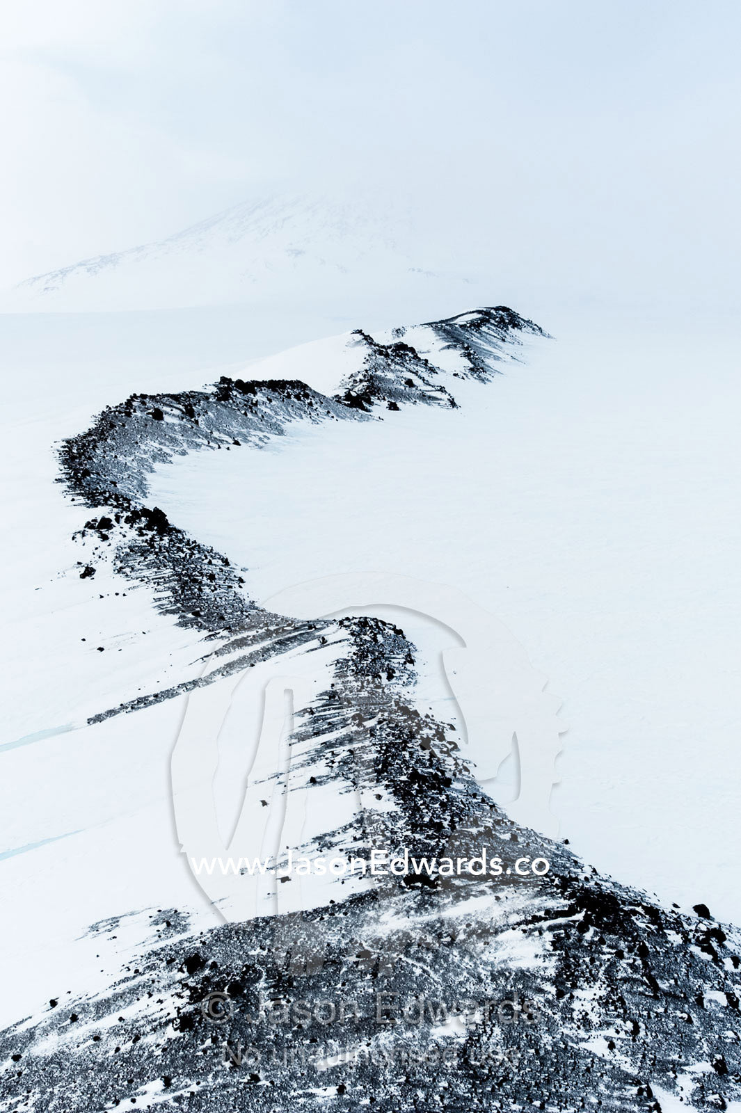 Ice sheets and snow cover the rocky slopes and ridges of Mount Erebus an active volcano. Western Slopes Mount Erebus, Ross Island, Antarctica.