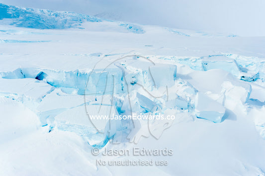 Treacherous crevasse scour the surface of a glacier leading onto the sea ice in Antarctica. Esser Bluff, Mount Erebus, Ross Island, Antarctica.