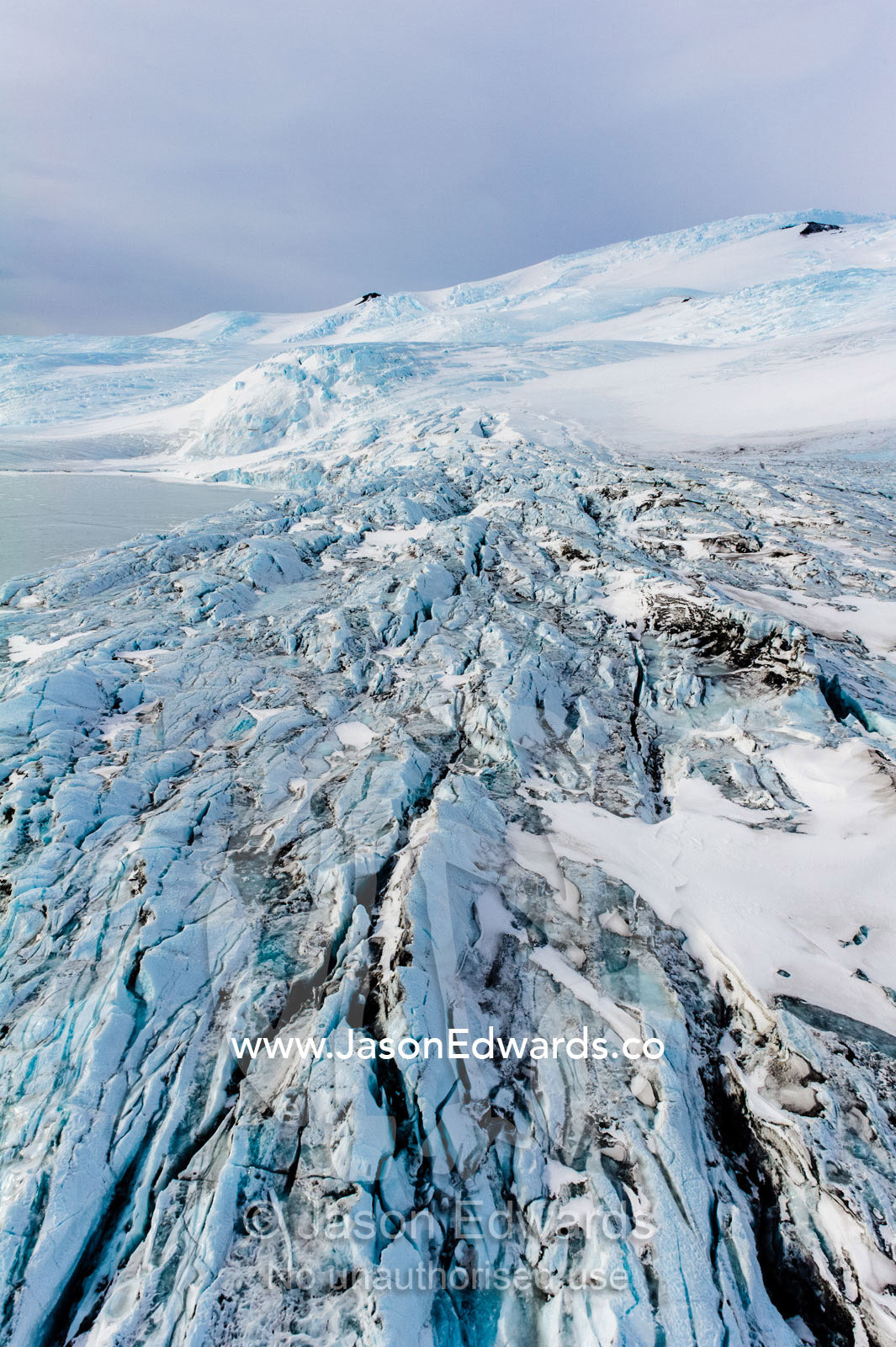 The fractured and tortured ice tongue of the Mt Erebus Glacier sweeps off the slopes of the active volcano. Pakaru Icefalls, South Bay, Ross Island, Antarctica.