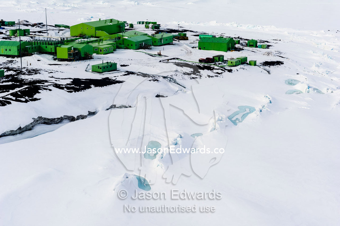 Sea ice pressure ridges rise along the shoreline in front of Scott Base in Antarctica. Scott Base, Pram Point, Hut Point Peninsula, Ross Island, Antarctica.