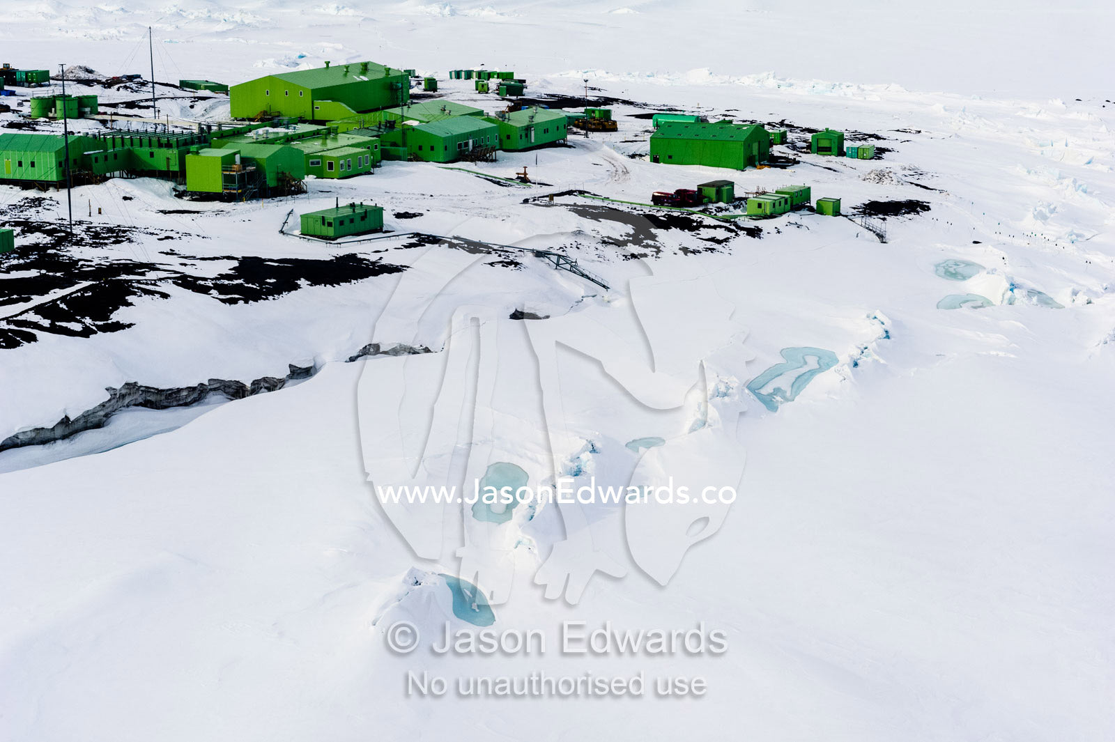 Sea ice pressure ridges rise along the shoreline in front of Scott Base in Antarctica. Scott Base, Pram Point, Hut Point Peninsula, Ross Island, Antarctica.