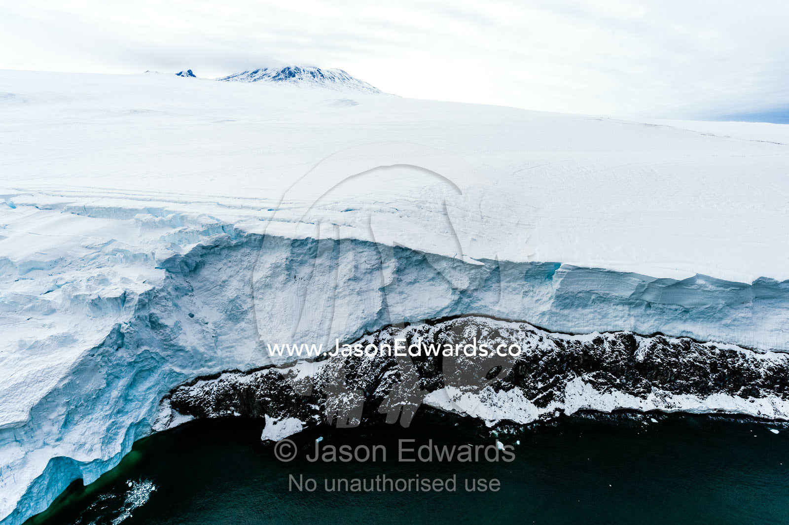 Towering ocean ice cliffs and crevasse fields of a glacier flowing off the slopes of Mount Erebus an active volcano. Wohlschlag Bay, Endeavour Piedmont, Mount Erebus, Ross Island, Antarctica.