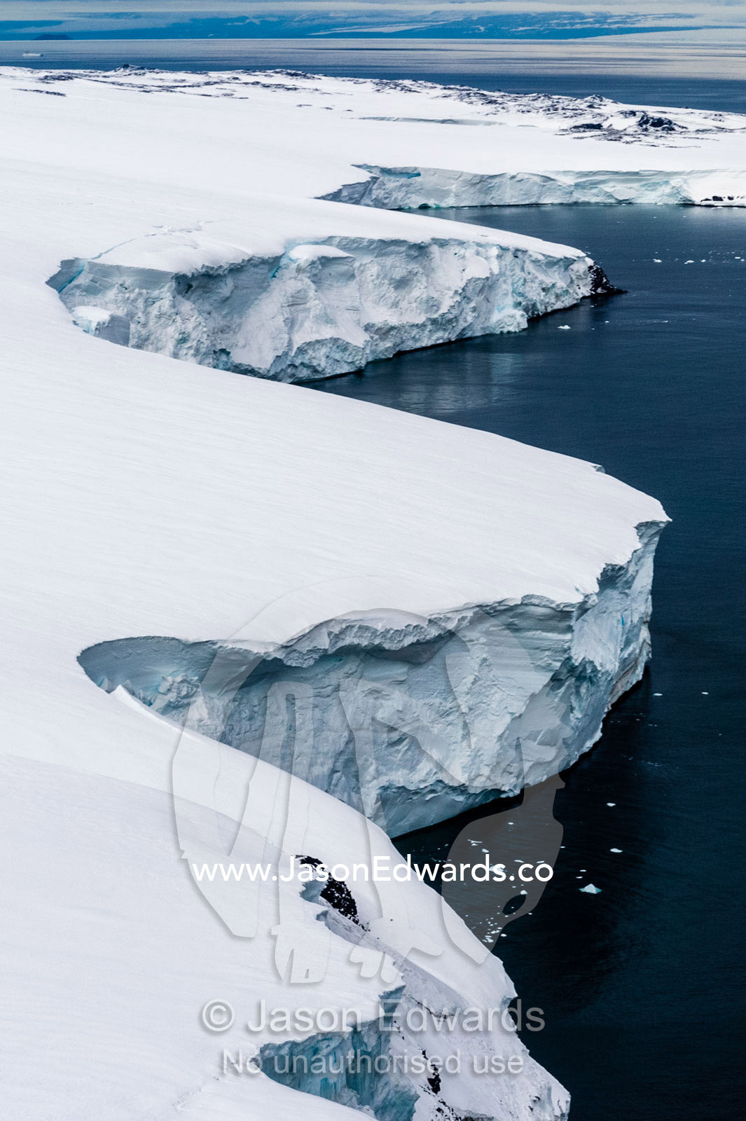 Towering ocean ice cliffs and crevasse fields of a glacier flowing off the slopes of Mount Erebus an active volcano. Wohlschlag Bay, Endeavour Piedmont, Mount Erebus, Ross Island, Antarctica.