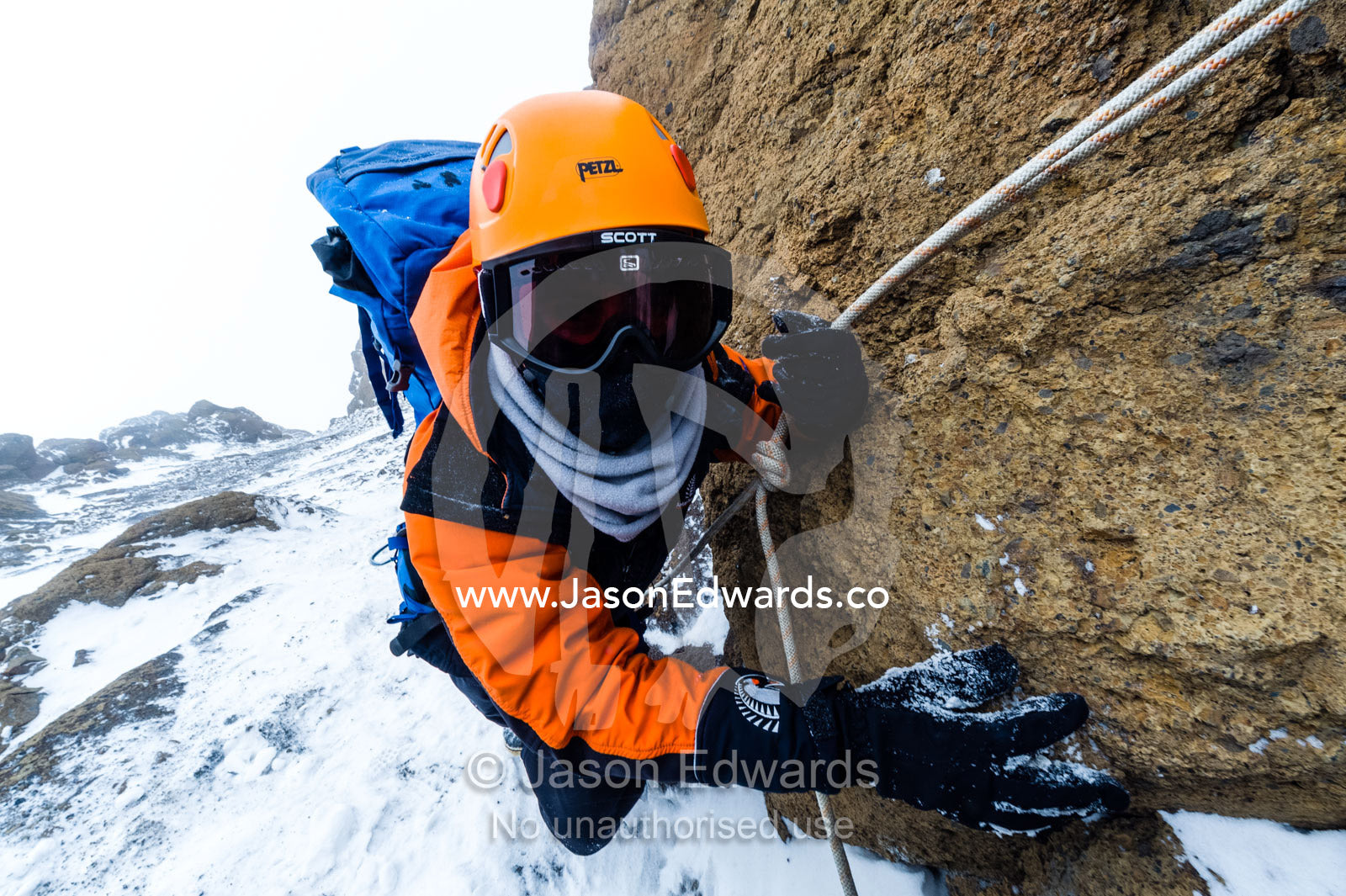 Mountain climbers using climbing ropes to scale a cliff overlooking the Ross Ice Shelf. Castle Rock, Hut Point Peninsula, Ross Island, Antarctica.