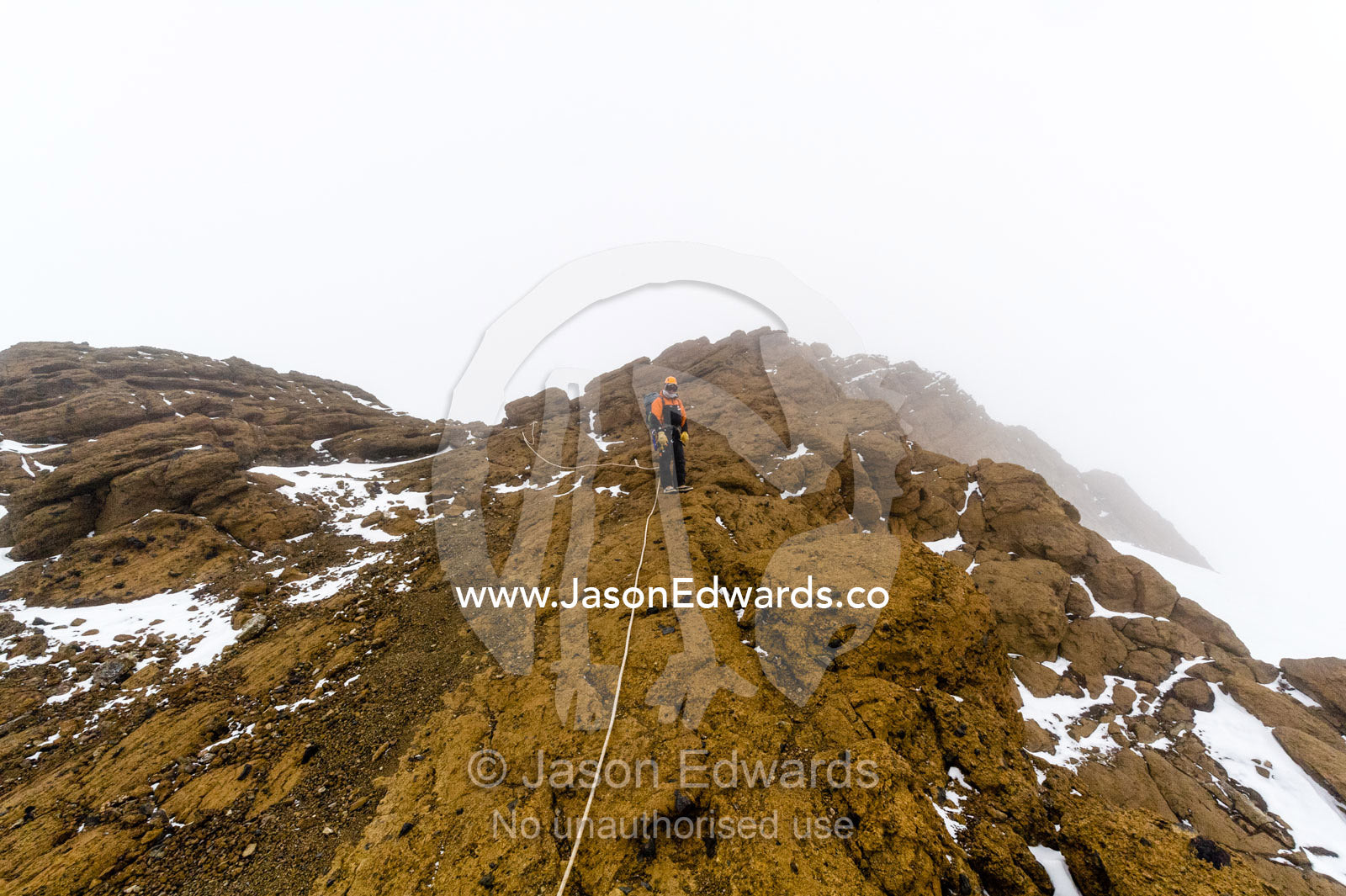 Mountain climbers using climbing ropes to scale a cliff overlooking the Ross Ice Shelf. Castle Rock, Hut Point Peninsula, Ross Island, Antarctica.