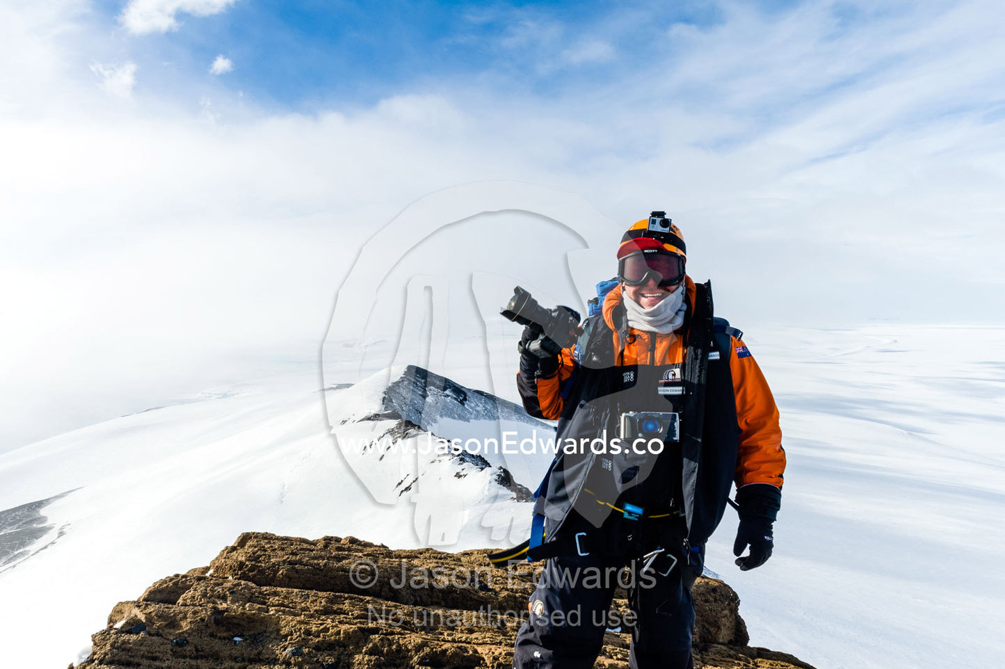 A photographer standing with his camera on a mountaintop in Antarctica. Breached Cone, Castle Rock, Hut Point Peninsula, Ross Island, Antarctica.
