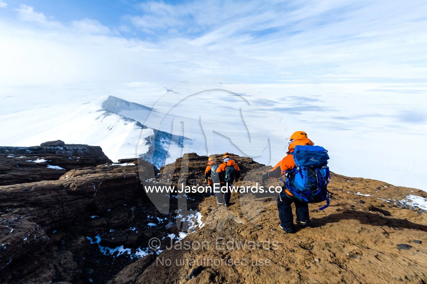 Mountain climbers descending from the summit above the Ross Ice Shelf. Breached Cone, Castle Rock, Hut Point Peninsula, Ross Island, Antarctica.