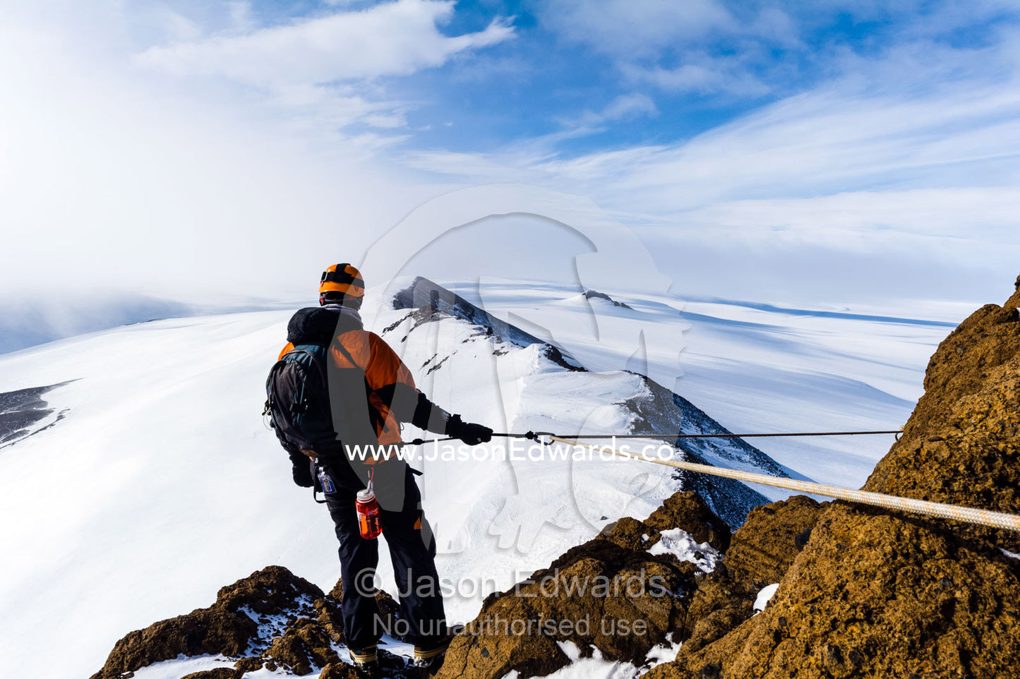 Mountain climbers using climbing ropes and carabiner to scale a cliff overlooking the Ross Ice Shelf. Breached Cone, Castle Rock, Hut Point Peninsula, Ross Island, Antarctica.