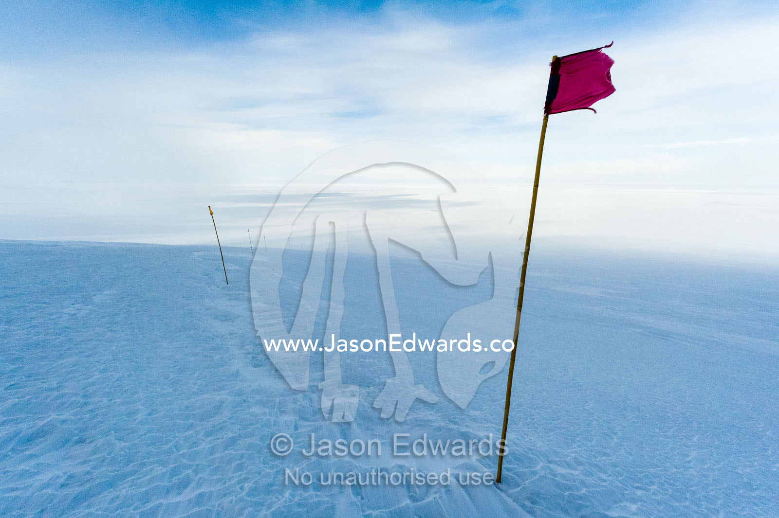A red flag highlights a safe route across the sea ice. Castle Rock Road, Hut Point Peninsula, Ross Island, Antarctica.