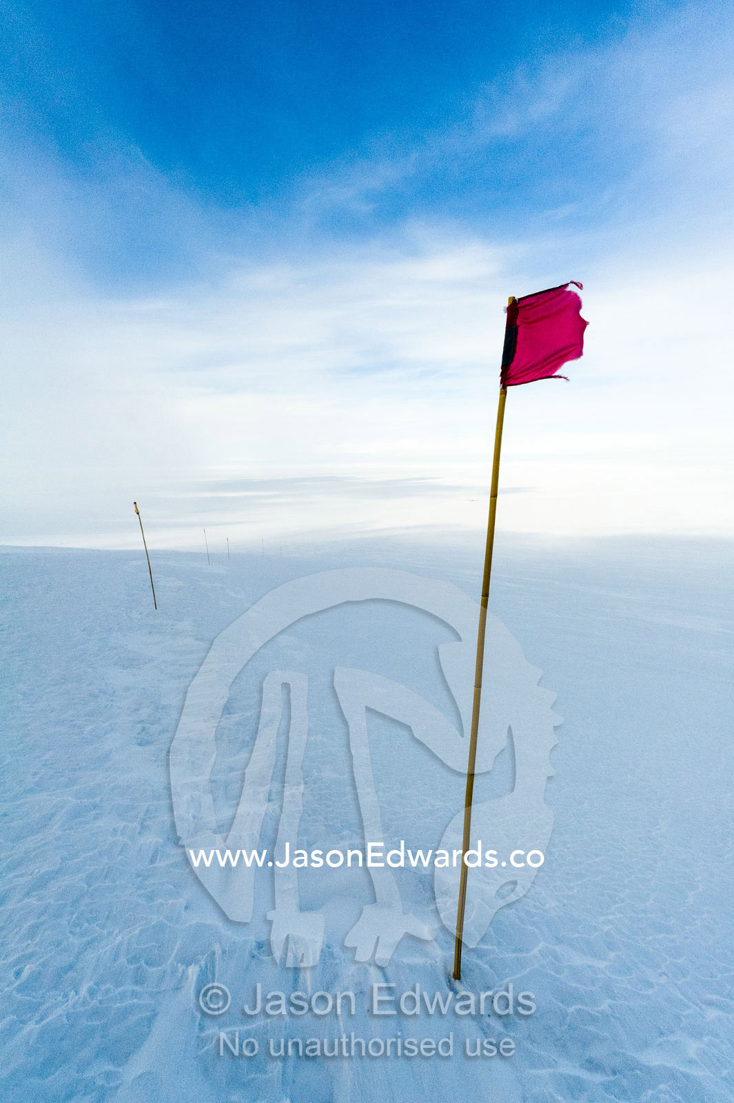 A red flag highlights a safe route across the sea ice. Castle Rock Road, Hut Point Peninsula, Ross Island, Antarctica.