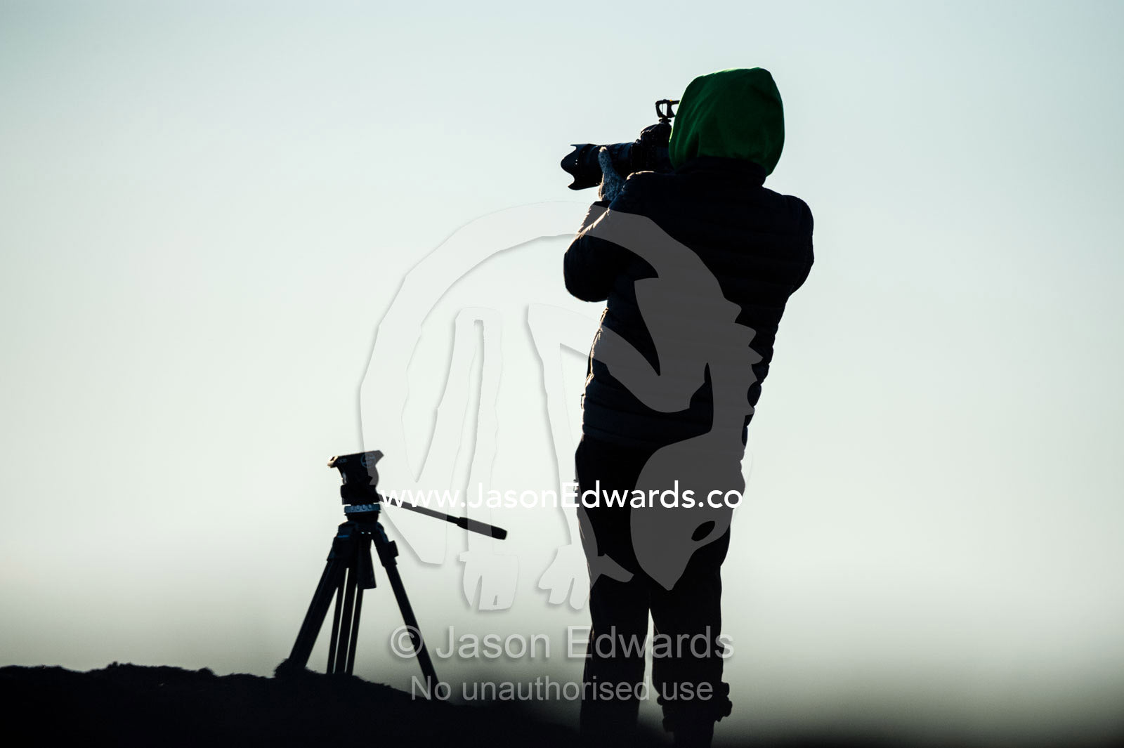 The silhouette of a photographer taking photographs of the sea ice. Scott Base, Pram Point, Hut Point Peninsula, Ross Island, Antarctica.