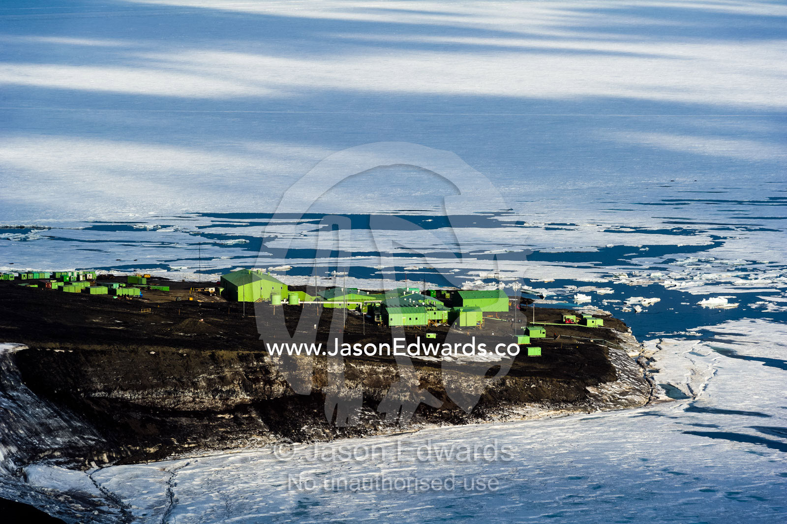 Tiny Scott Base perched on an outcrop of rock overlooking the sea ice in Antarctica. Scott Base, Pram Point, Hut Point Peninsula, Ross Island, Antarctica.