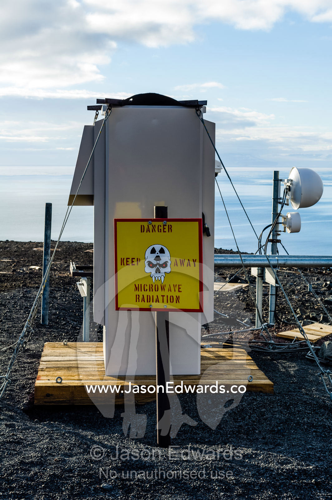 Skull and fang warning signs at a dangerous microwave radiation research site. McMurdo Station, Ross Island, Antarctica.