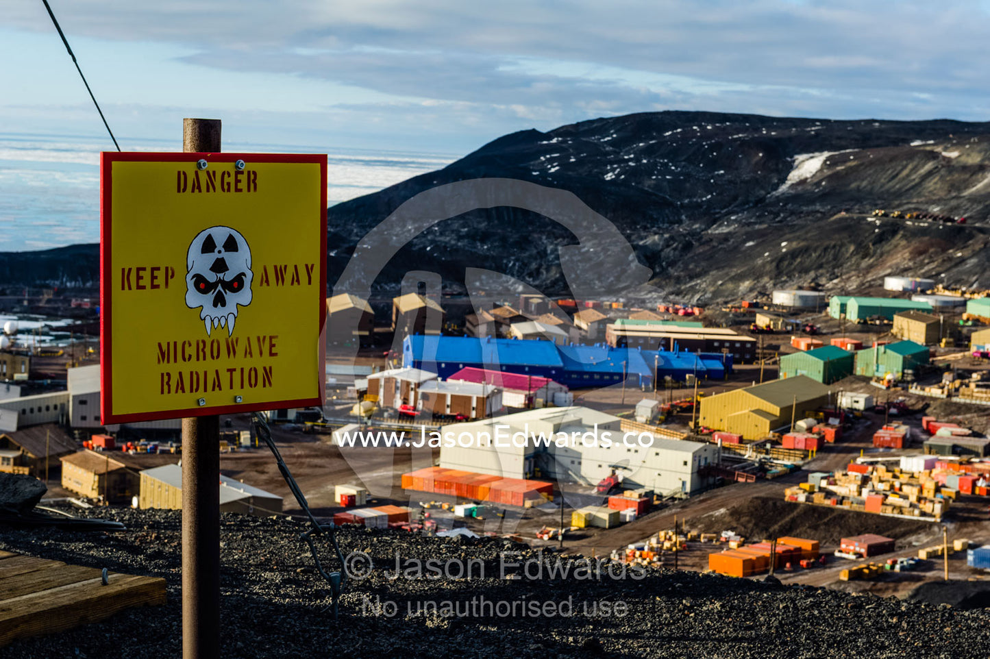 Skull and fang warning signs at a dangerous microwave radiation research site. McMurdo Station, Ross Island, Antarctica.