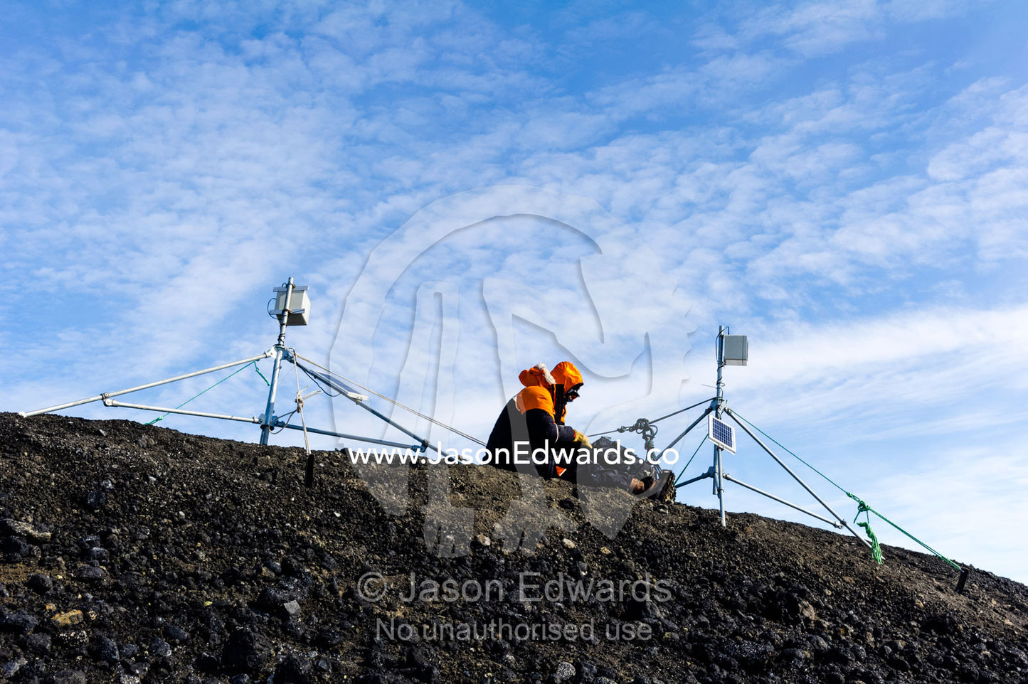 A scientific researcher working on a laptop computer on a mountaintop in Antarctica. Turtle Rock, Erebus Bay, McMurdo Sound, Ross Island, Antarctica.