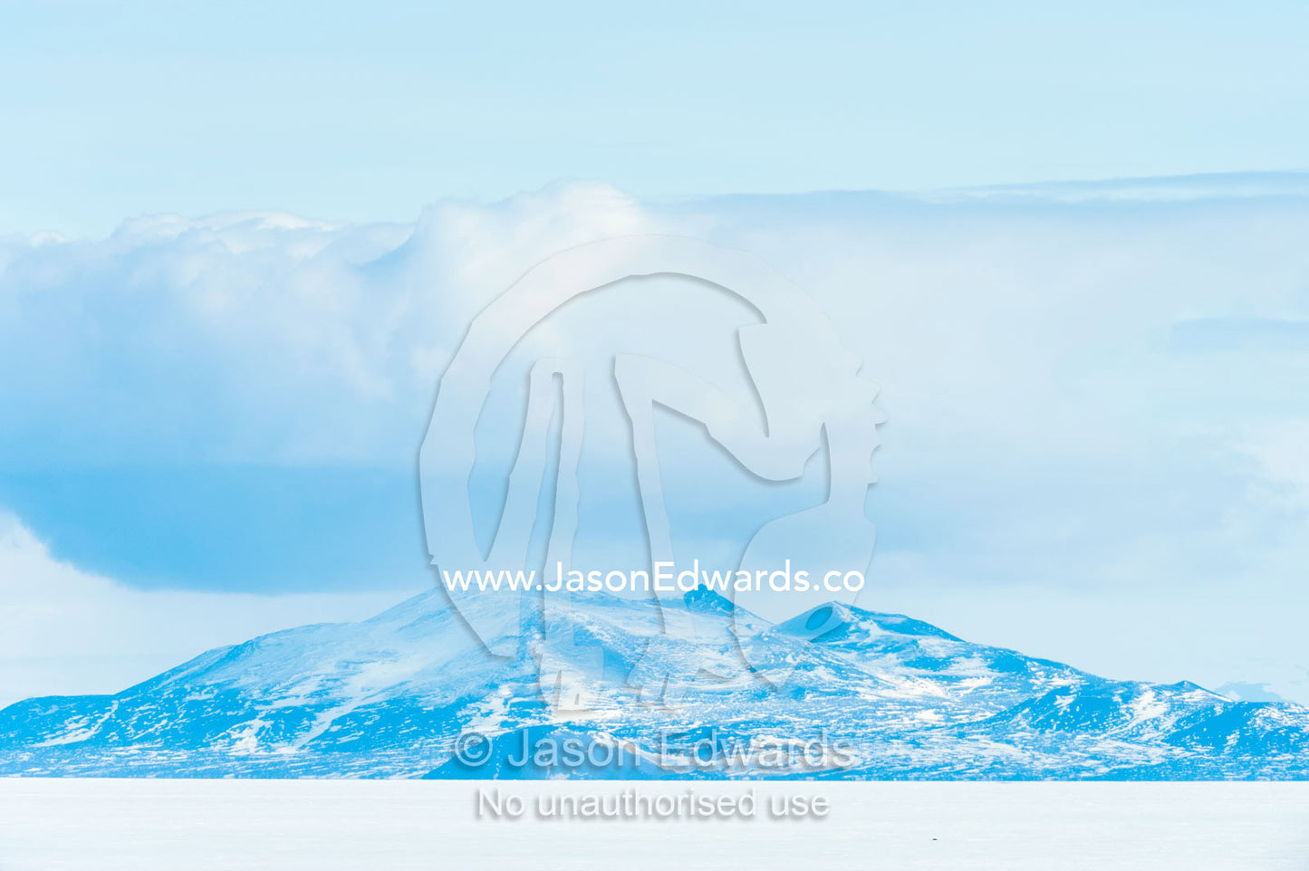 Bleak and inhospitable mountains overlook the featureless sea ice in Antarctica. Royal Society Range, McMurdo Sound, Ross Island, Antarctica.