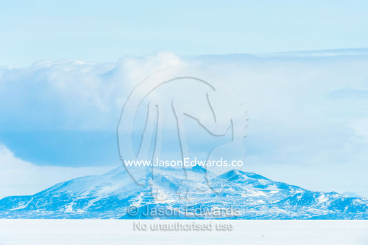 Bleak and inhospitable mountains overlook the featureless sea ice in Antarctica. Royal Society Range, McMurdo Sound, Ross Island, Antarctica.
