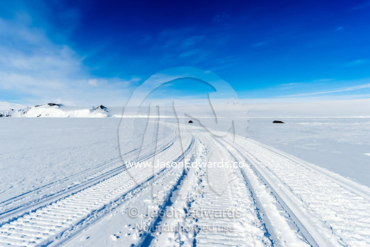 Skidoo tracks cross the frozen sea ice in Antarctica. Turtle Rock, Erebus Bay, McMurdo Sound, Ross Island, Antarctica.