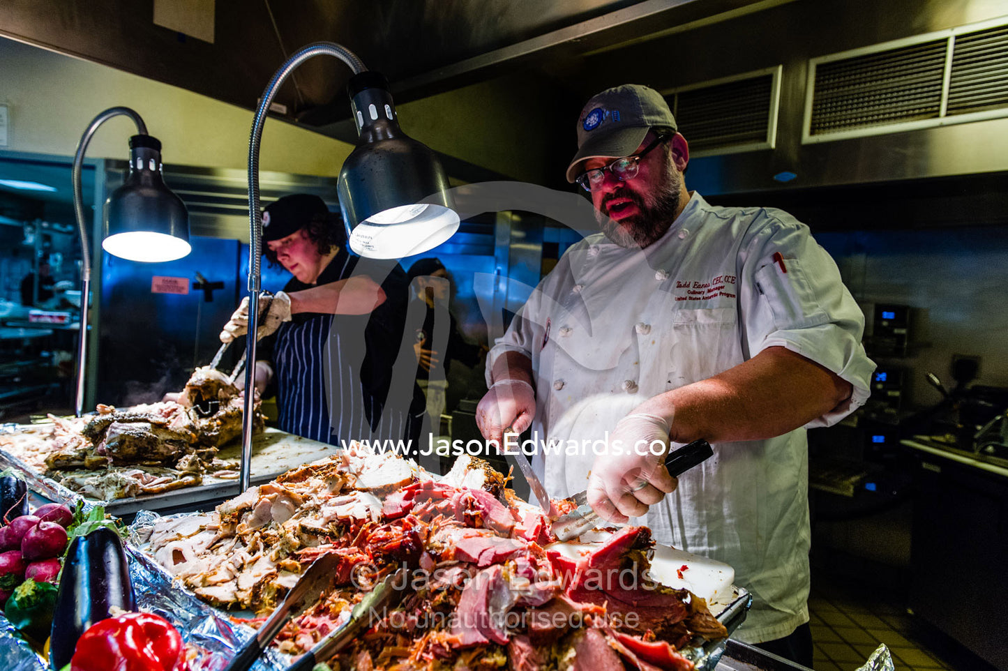 A chef carves meat for Thanksgiving in an Antarctic base restaurant. McMurdo Station, Ross Island, Antarctica.