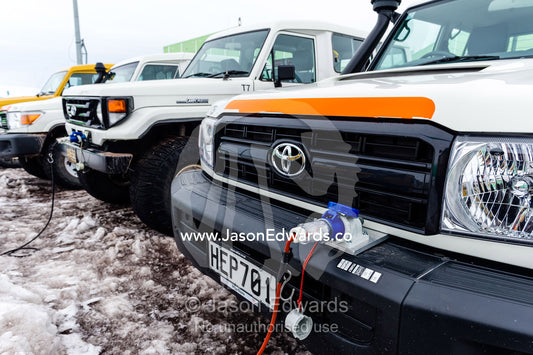 A group of 4wd vehicles plugged into the electricity when not being used during the Antarctic summer. Scott Base, Pram Point, Hut Point Peninsula, Ross Island, Antarctica.