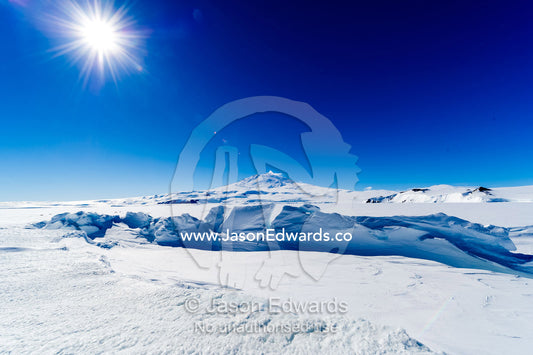 Pressure ridges in the sea ice form a barrier to Mount Erebus an active volcano in Antarctica. Mount Erebus, Turtle Rock, Erebus Bay, McMurdo Sound, Ross Island, Antarctica.