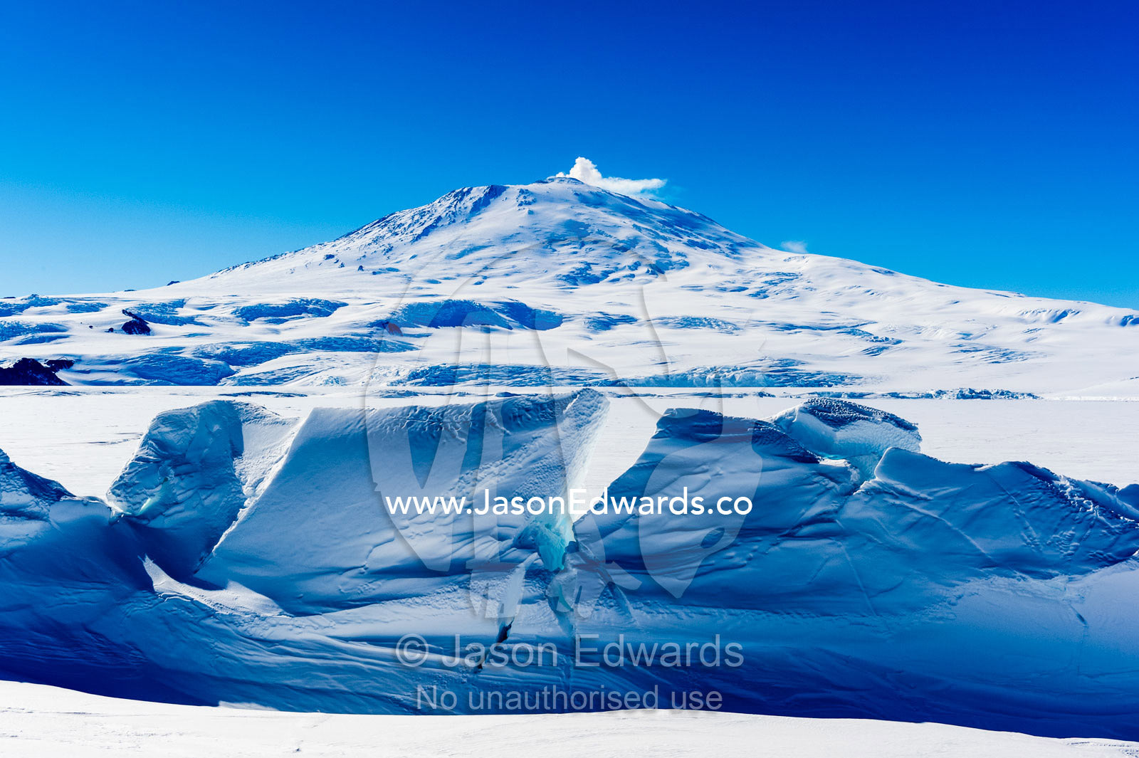 Pressure ridges in the sea ice form a barrier to Mount Erebus an active volcano in Antarctica. Mount Erebus, Turtle Rock, Erebus Bay, McMurdo Sound, Ross Island, Antarctica.
