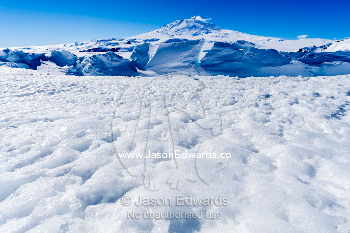 Pressure ridges in the sea ice form a barrier to Mount Erebus an active volcano in Antarctica. Mount Erebus, Turtle Rock, Erebus Bay, McMurdo Sound, Ross Island, Antarctica.