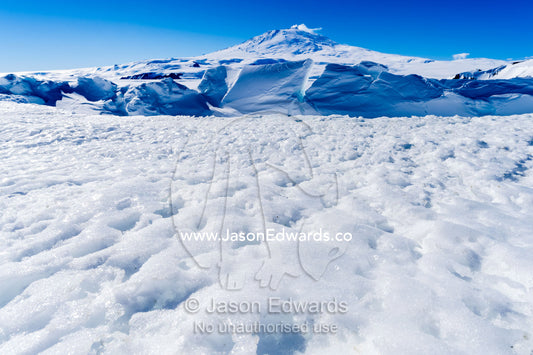 Pressure ridges in the sea ice form a barrier to Mount Erebus an active volcano in Antarctica. Mount Erebus, Turtle Rock, Erebus Bay, McMurdo Sound, Ross Island, Antarctica.