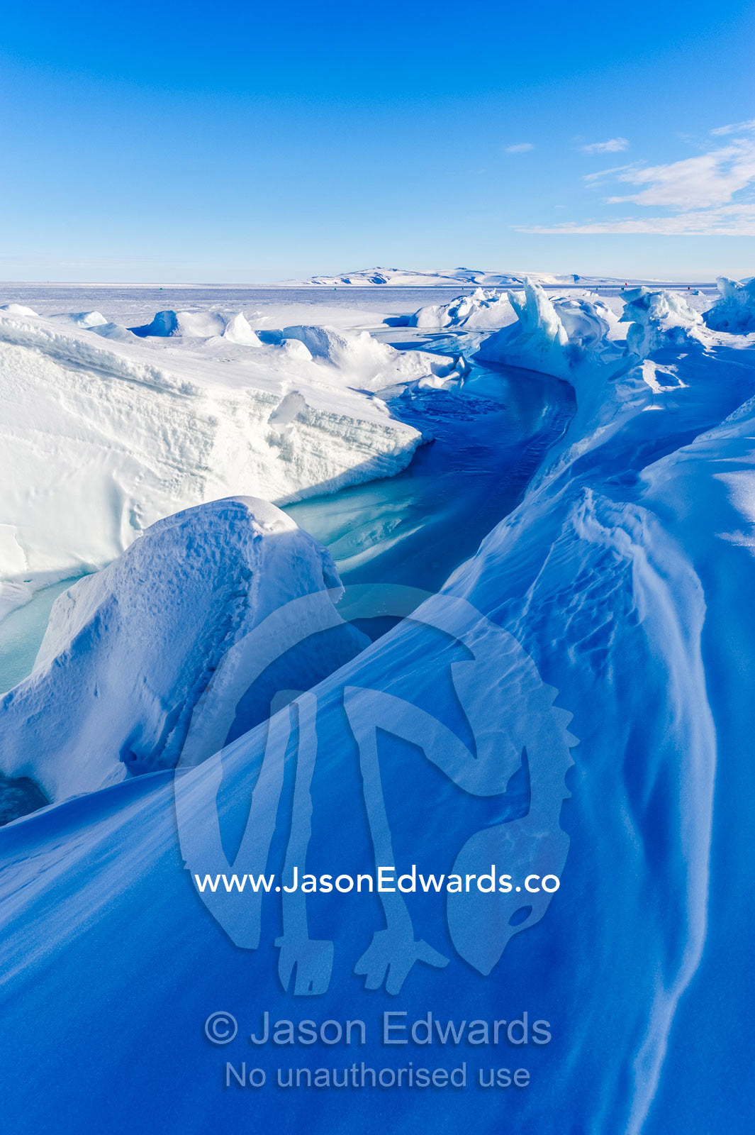 Enormous blocks of ice are pushed skyward along pressure ridges as the sea ice thins and forms melt pools. Pram Point, McMurdo Sound, Ross Island, Antarctica.