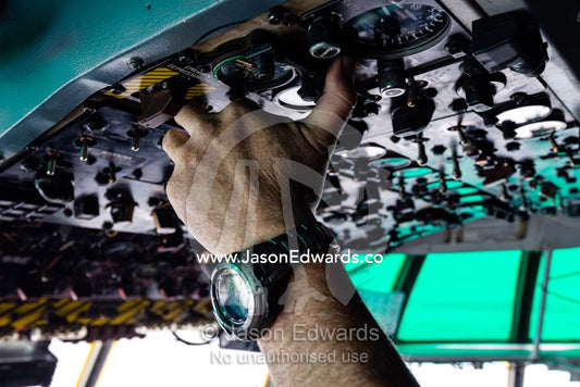 The South African pilot of a US air force Hercules flight crew flicking switches in the cockpit flying to Antarctica. Pegasus Field, Ross Island, McMurdo Sound, Antarctica.