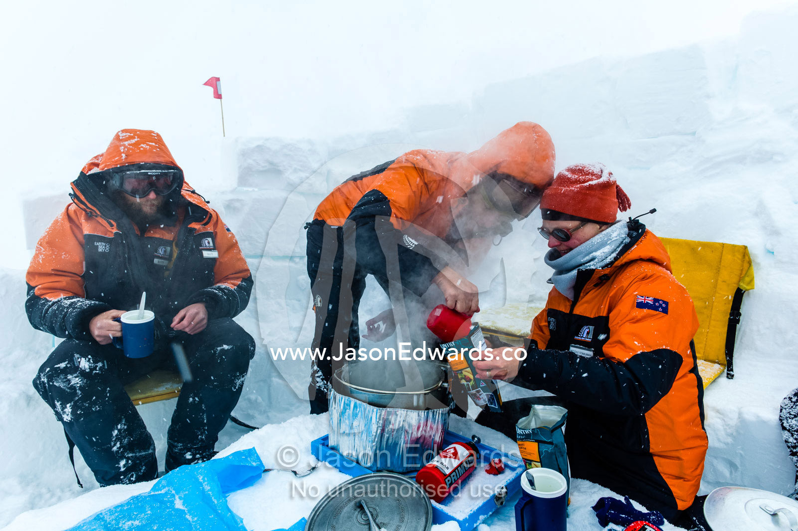 Antarctic base staff eating a meal behind a kitchen wall in a blizzard on the sea ice during a survival course. Windless Bight, Ross Ice Shelf, Ross Island, Antarctica.